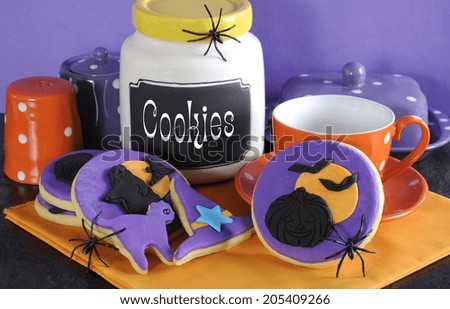 Happy Halloween party trick or treat purple and orange cookies with spiders and cookie jar.