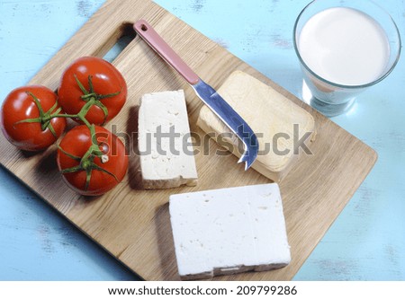 Health food healthy diet food group, dairy free products, with soy milk, tofu, soy cheese, and goats cheese on wood chopping board and blue vintage tray background.