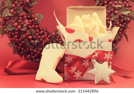Christmas gift box of shortbread biscuit cookies with festive ornament decorations left out for Santa with retro vintage filter.
