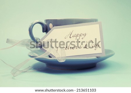 Happy Fathers Day gift tag with a cup of coffee or tea for Dad in a blue polka dot cup and saucer against a blue background, with retro vintage style filter.