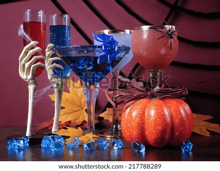 Happy Halloween ghoulish party cocktail drinks with spider web and decorations on purple background.