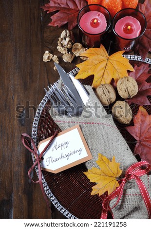 Happy Thanksgiving dining table place setting in traditional rustic country style with hessian wrapped cutlery on rustic wood background.