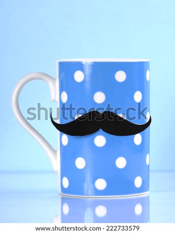 November fund raising for mens health awareness charity with mustache on blue polka dot coffee mug cup on blue background.