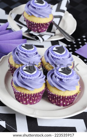 Black and white chevron with purple theme party luncheon table place setting for Melbourne Cup, Australian public holiday, horse race event with cupcakes closeup.
