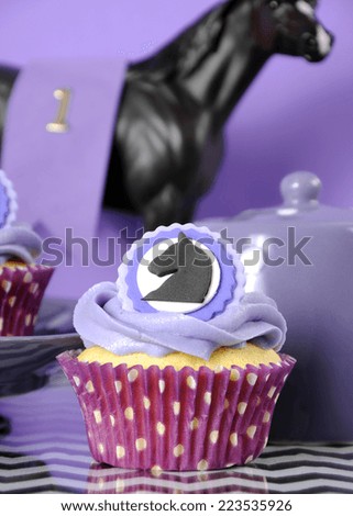 Black and white chevron with purple theme party luncheon table place setting for Melbourne Cup, Australian public holiday, horse race event cupcake - vertical closeup.