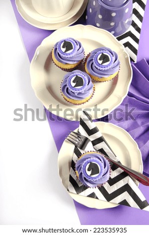 Black and white chevron with purple theme party luncheon table place setting for Melbourne Cup, Australian public holiday, horse race event cupcakes with copy space vertical.