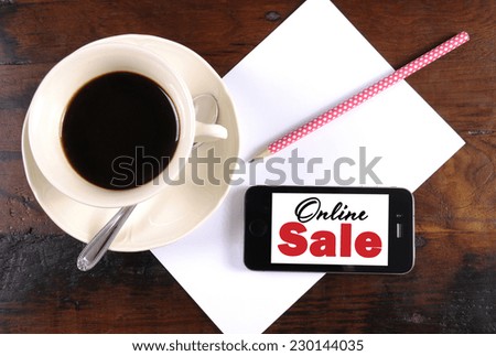 Online Sale message on phone device with cup of coffee, pencil and paper for Cyber Monday Sales