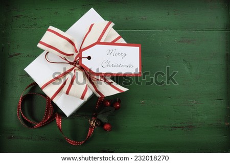 Christmas holiday background with red, white gift against a vintage style dark green recycled wood background.