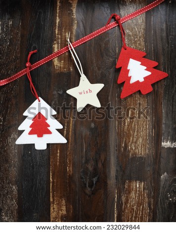 Christmas holiday background on dark recycled wood with festive hanging felt tree decorations - vertical.