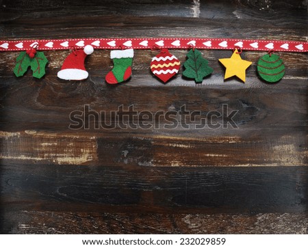 Christmas holiday background on dark recycled wood with hanging childrens felt decorations