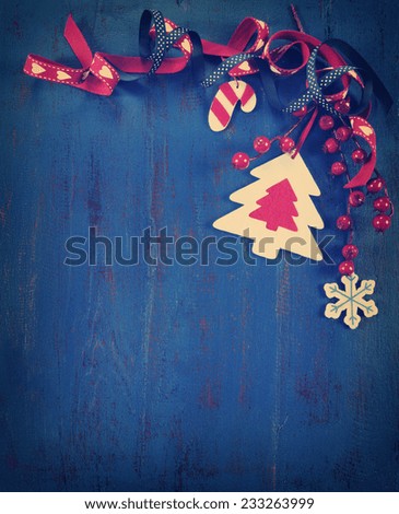 Vintage Christmas holiday background with festive natural style wood and felt ornaments on a dark royal blue vintage recycled wood background. Vertical.