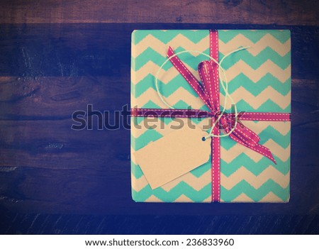 Retro vintage gift box with chevron stripe wrapping on dark recycled wood table.