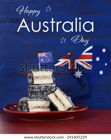 Happy Australia Day January 26 party food with iconic Australian lamington cakes on dark red and blue vintage rustic recycled wood background, with sample text.