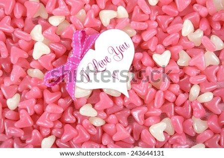 Valentines Day pink and white heart shape jelly candy confectionary on pink wood background with heart greeting card and sample text.