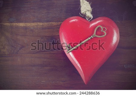 Retro vintage style Happy Valentines Day key to my heart concept with large hanging heart on dark wood background, with copy space.