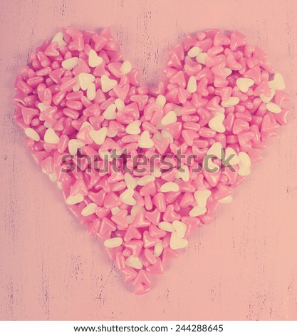 Retro vintage style Happy Valentines Day pink and white heart shape jelly candy on pink wood background.