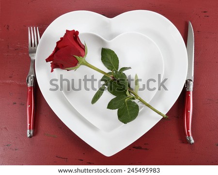 Happy Valentines Day table place setting on red vintage wood background with red rose, overhead.