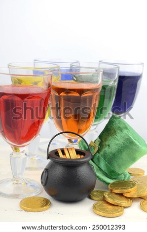 Happy St Patricks Day party rainbow color drinks with decorations on vintage wood table.