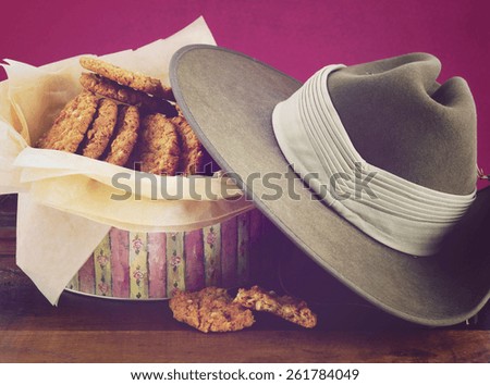 Australian Anzac biscuits in vintage biscuit tin with army soldier slouch hat, and applied retro vintage style filters.