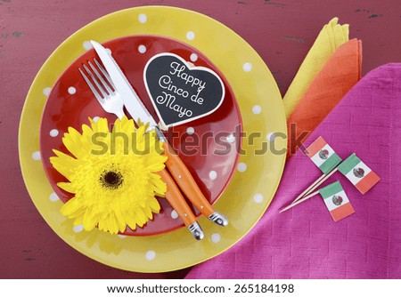 Happy Cinco de Mayo bright colorful party table place setting with bright gerbera daisy flowers on distressed red wood table.