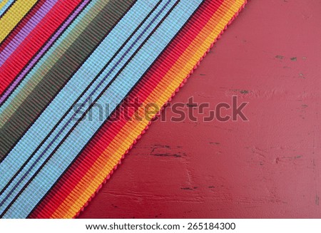 Happy Cinco de Mayo background with Mexican style fabric on distressed red wood table.