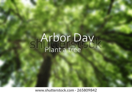 Arbor Day concept with blurred background image of tall tree canopy with added text.