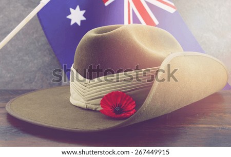 Anzac army slouch hat with Australian Flag on vintage wood background with applied retro vintage filters and added light effects.