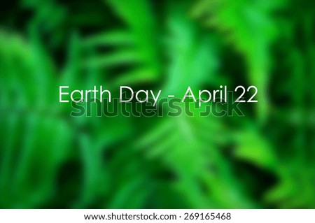 Earth Day, April 22, text title with blurred background of lush green ferns.