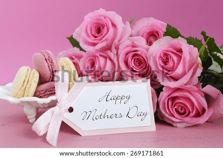 Happy Mothers Day Pink Roses and macarons on vintage style distressed pink wood table.
