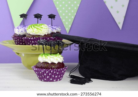 Graduation Day green and purple theme party with cupcakes and graduation cap toppers.