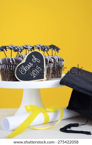Happy Graduation Day party chocolate cupcakes with graduation cap hat topper decorations, in yellow, black and white party theme.