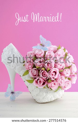Wedding day pink and white bouquet of silk roses with blue butterflies and white high heel shoe.