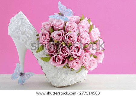 Wedding day pink and white bouquet of silk roses with blue butterflies and white high heel shoe.