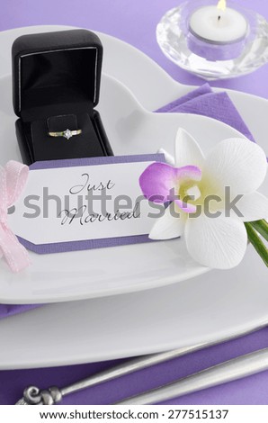 Purple theme wedding table place setting with heart shape plates and vintage silverware.