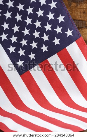 USA Stars and Stripes Flag on Dark Wood, draped, vertical.