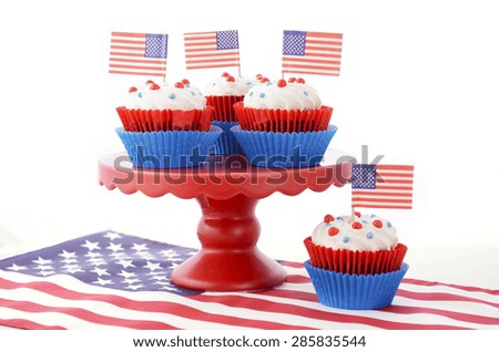 Happy Fourth of July Cupcakes on red stand with USA flags on white wood shabby chic table.