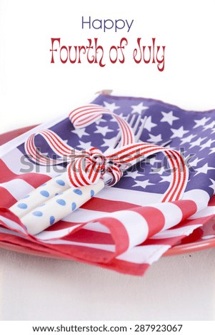 Patriotic table place setting with USA flag and polka dot plate on white wood shabby chic table for Fourth of July and USA holiday and events celebration.