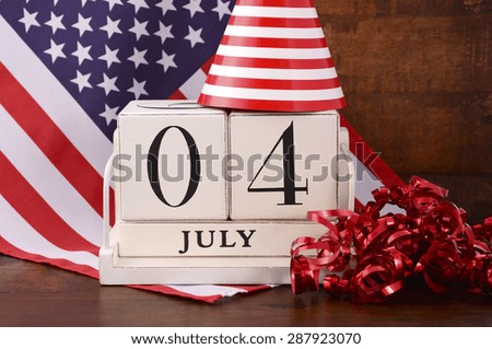 Fourth of July vintage wood calendar with flag and party hat and decorations on dark wood rustic background.