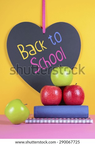 Back to School or Education Concept with apples, books and heart shape blackboard with sample text.