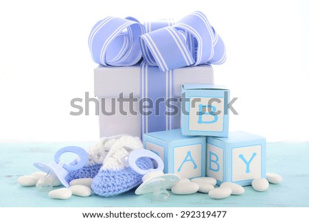 Baby shower Its a Boy blue gift, with gift box, baby booties and dummy on pale blue shabby chic rustic wood table.