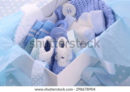 Its a Boy blue theme baby shower gift box with baby clothes, bib, bonnet, booties, pacifier and socks.