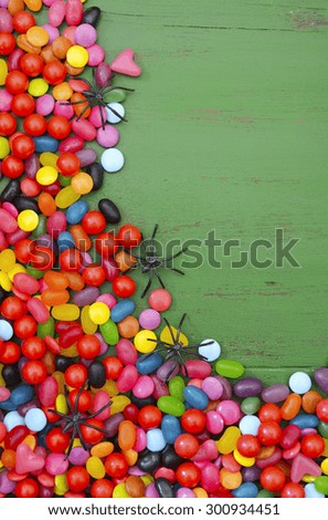 Halloween rustic green wood background with candy and spiders, with copy space for your text here.
