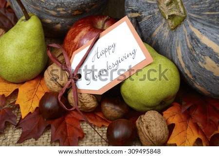 Happy Thanksgiving Pumpkin in Rustic Setting on burlap covered table with greeting message, closeup.