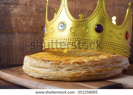 Epiphany Twelfth Night Cake, Almond Galette des Rois, Cake of the Kings, on dark wood rustic background.