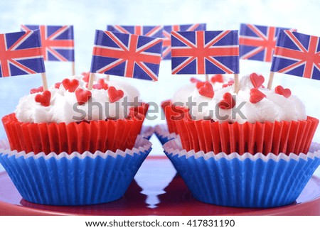 Holiday party cupcakes with UK flags on red cake stand on large flag.