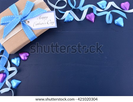 Happy Fathers Day background on dark blue distressed wood table with decorated borders.
