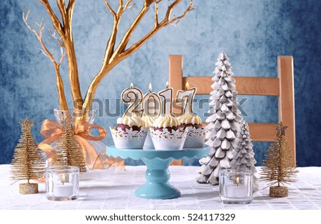 Happy New Year 2017 cupcakes on a modern stylish, festive, blue gold and white Winter theme table setting