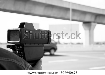 black and white catch speeding drivers with a radar gun