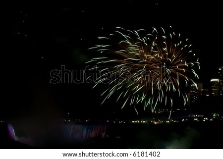 firework going off above the waterfall looks like a chrysanthemum.