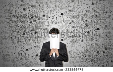Business man covering his face with blank paper on business and technology background